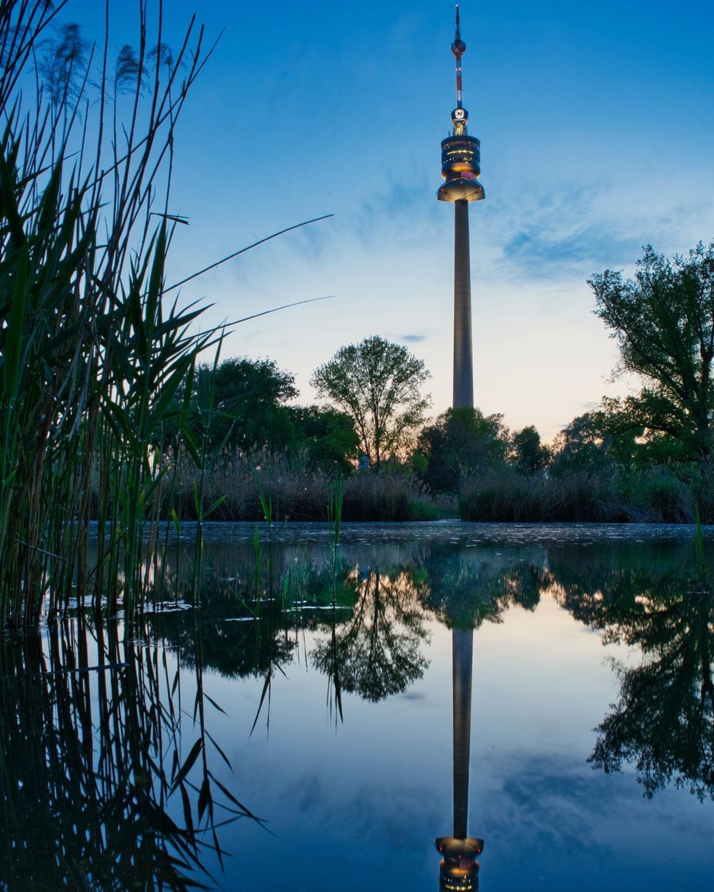 We are located in beautiful surrounding by 📷 @roessler_photography<br />
.<br />
.<br />
.<br />
.<br />
#blauestunde #landschaftsfotografie #sonnenuntergang #architektur #nature #natur #wien #donaupark #donauturm #see #teich #wasser #wasserspiegelung #spiegelung #landscapefotography 